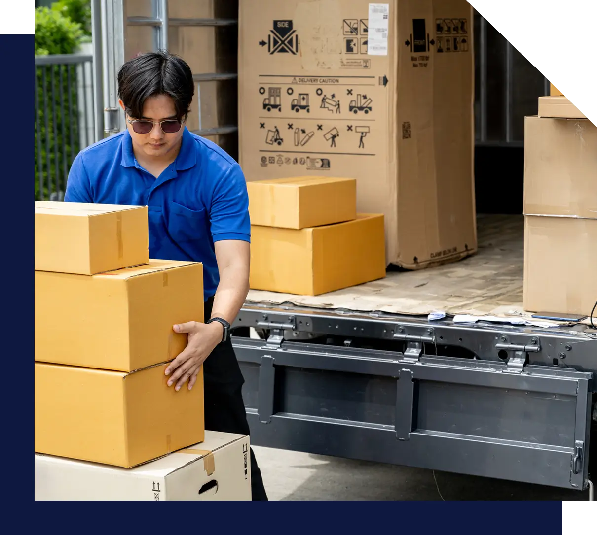 Person stacking boxes near a delivery truck.