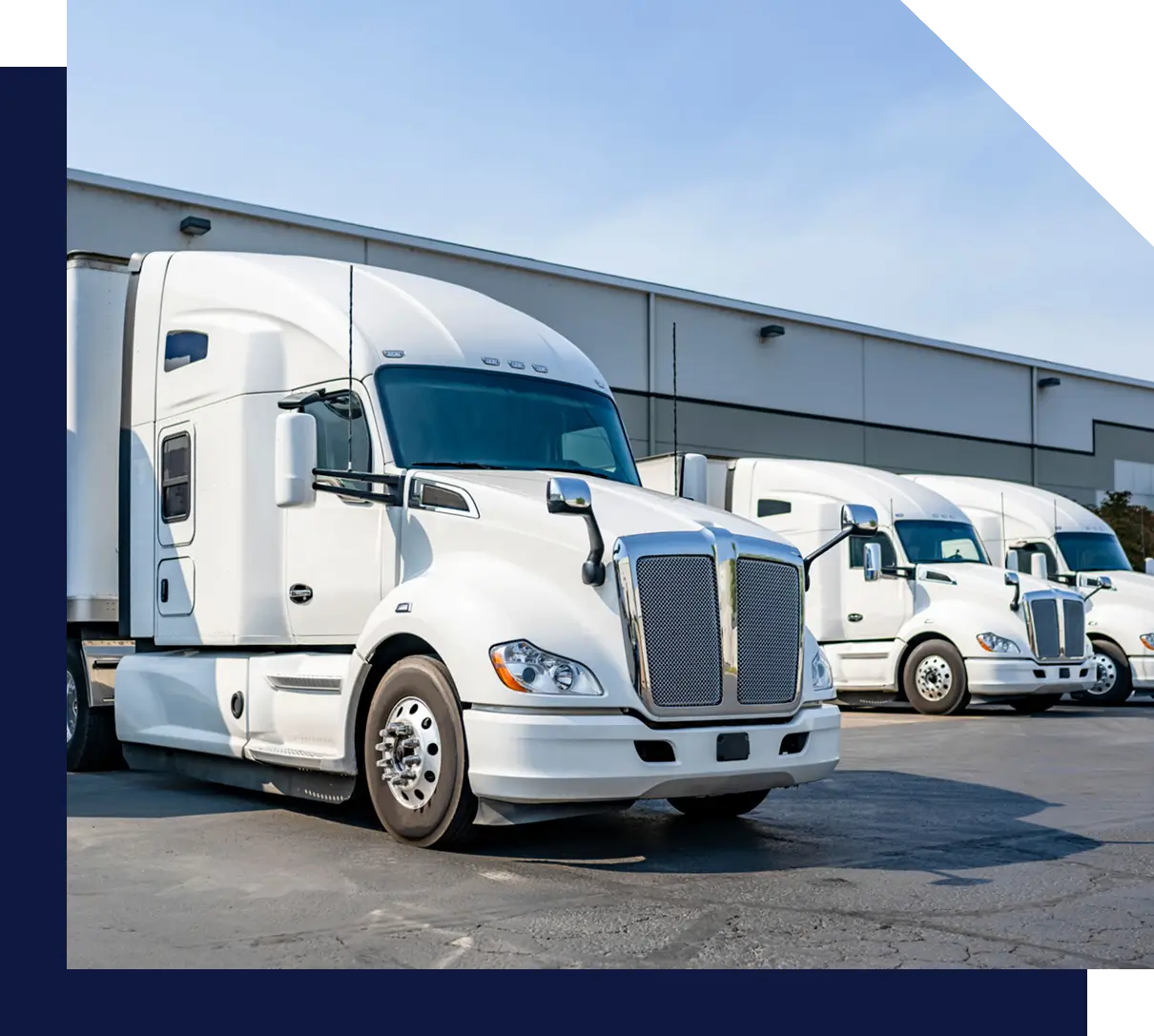 White semi-trucks parked at a warehouse.