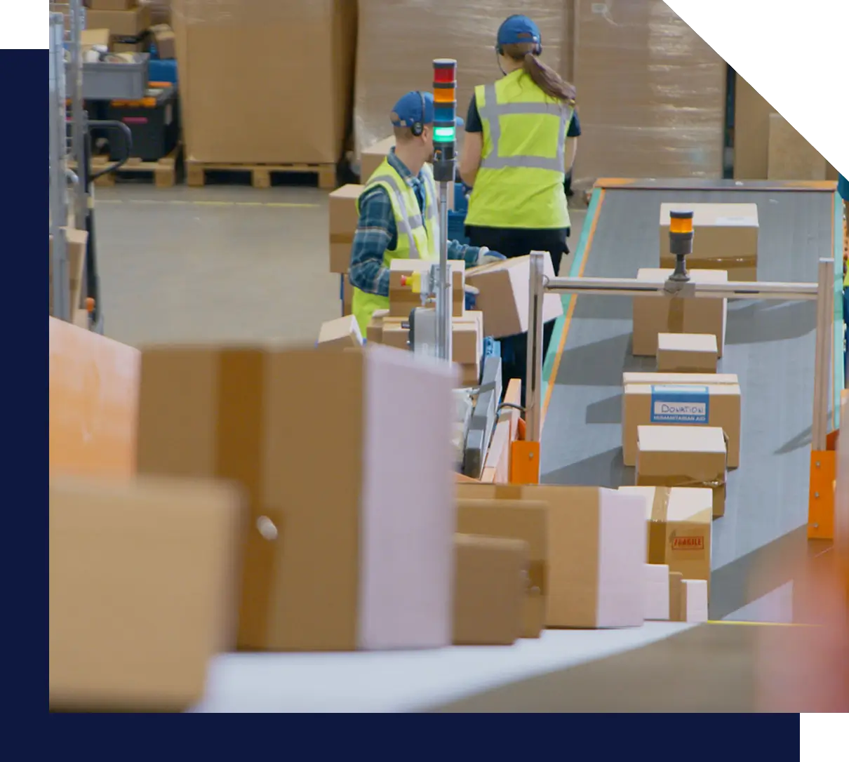 Warehouse workers sorting packages on conveyor belt.